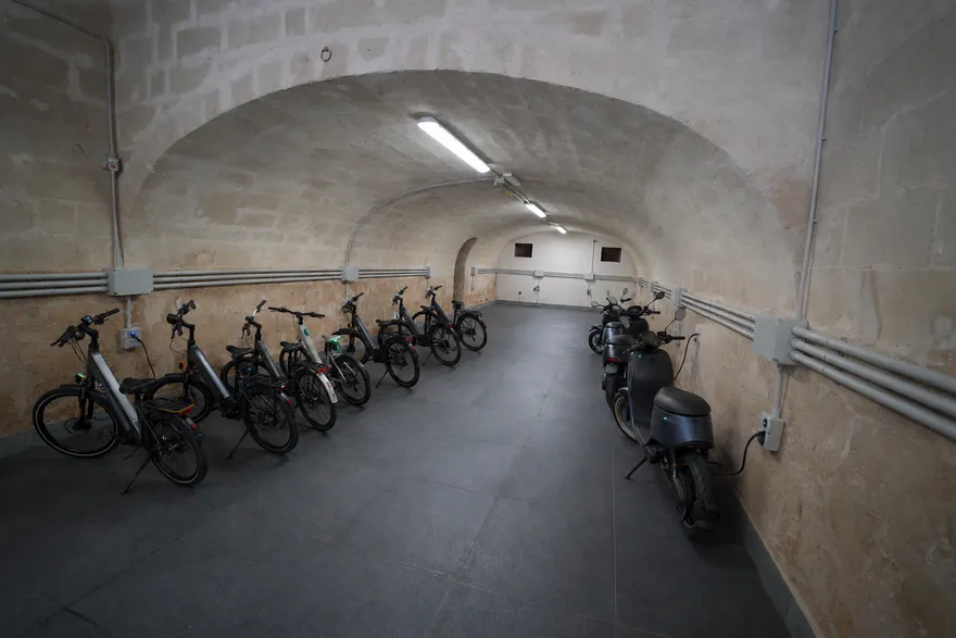 E-bike e scooter parcheggiati sotto la volta in tufo del Tataranni Garage a Matera