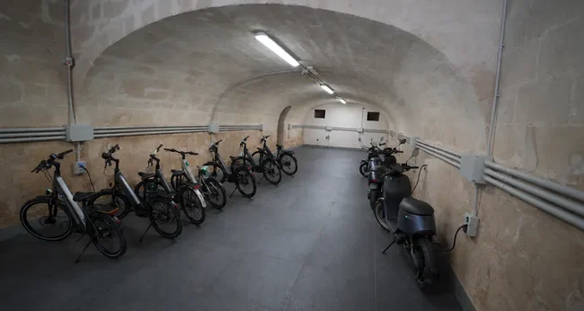 E-bike e scooter parcheggiati sotto la volta in tufo del Tataranni Garage a Matera